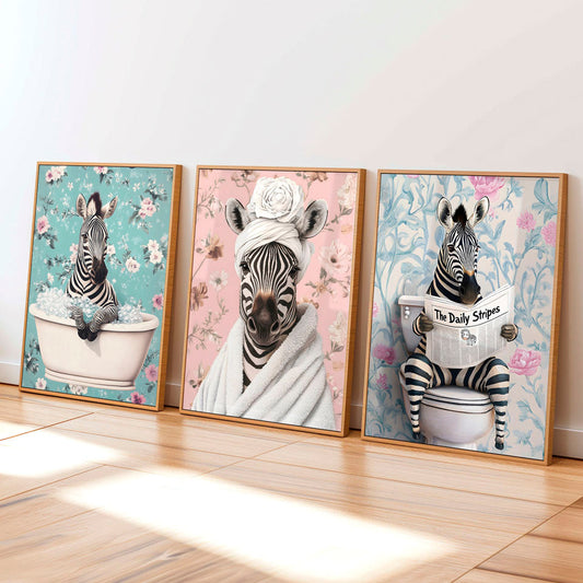 three framed pictures of zebras in a bathroom